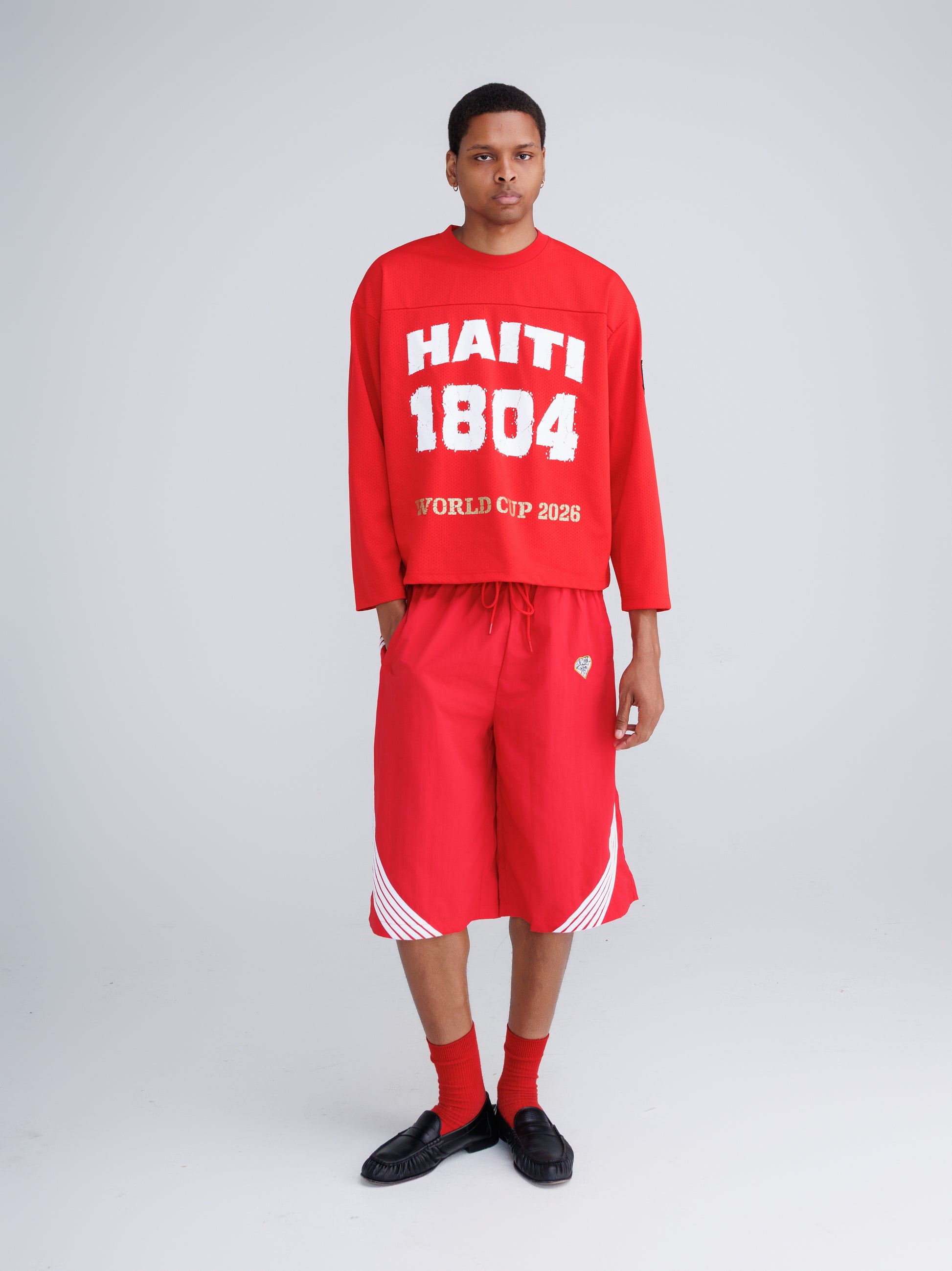 Haiti '26 Tee — Amends of the Heart, worn oversized on female model, black and white photographic multi-location print